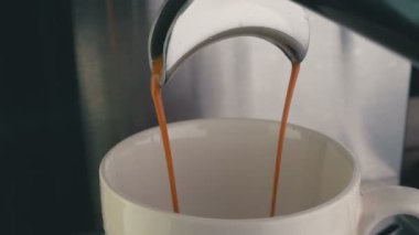 Barista, otomatik Espresso makinesinin çektiği kör filtreden kahve içti. Yüksek açı, yakın çekim ve yörünge kamerası görüntüsü.