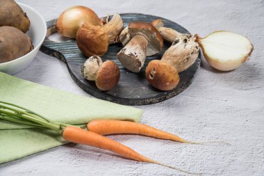 Hafif arka planda beyaz orman mantarları. Organik mantar pişiriyorum. Yaz hasadı. Yatay konum