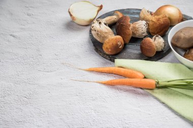 Hafif arka planda beyaz orman mantarları. Organik mantar pişiriyorum. Yatay konum. Kopyalama alanı