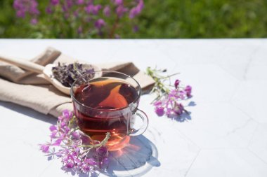 Mayalanmış kipreya yapraklarından elde edilen bitkisel çay hafif bir arka planda, bira bej bir peçetenin üzerindeki tahta kaşıkta yatar. Geleneksel Rus Kopor Tea (Ivan-Tea). Yatay düzenleme