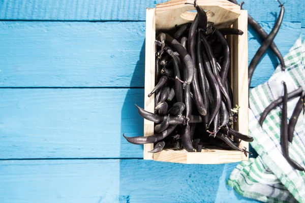 Ahşap mavi arka planda ahşap bir kutuda kuşkonmaz fasulyesi tohumları. Mavi bir peçete. Sebze proteini kaynağı. Sağlıklı beslenme kavramı. Kopyalama alanı