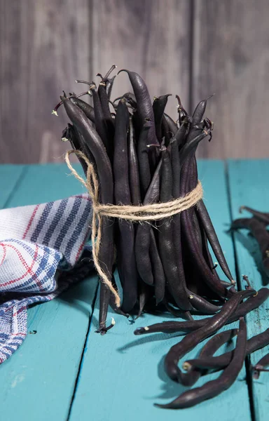 Renkli ahşap arka planda yayılmış fasulye kabukları. Sebze proteinlerinin kaynağı. Dikey yönelim.