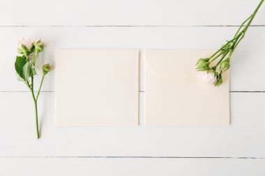 Pembe Gül boş zarflarla. Minimalist düz yatıyordu, Beyaz ahşap arka plan. Tasarım için yaratıcı sahte