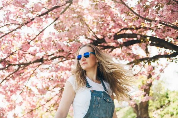 Молодые женщины хипстера с длинными светлыми волосами, носящие солнцезащитные очки. Чувствует себя свободным и счастливым. — стоковое фото