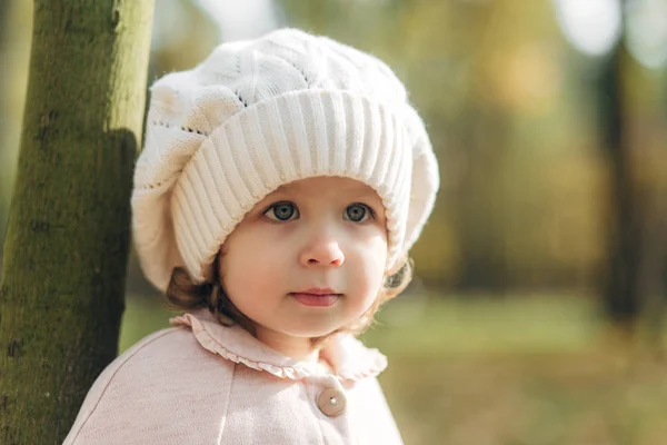 Το πορτρέτο ενός μικρού ομορφου κοριτσιού στο πάρκο, έξω. Φθινοπωρινό χρόνο. Φορώντας πλεκτό καπέλο. — Φωτογραφία Αρχείου