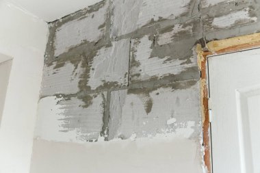 Tadilat sırasında duvar. Alçıyla kaplanmış köpük bloğu. Alçı duvarlar..