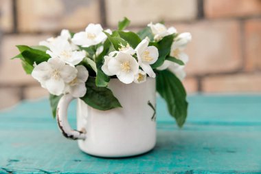 Yasemin çiçekleri kırsal metal bardakta.