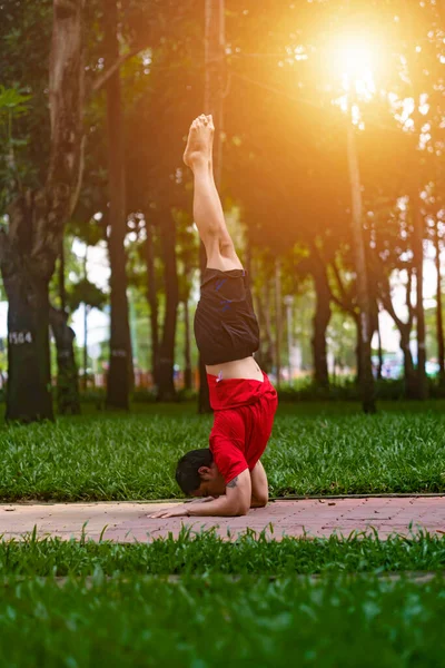 Young asian man are wiping sweat and doing yoga exercises in park. Yoga concept.