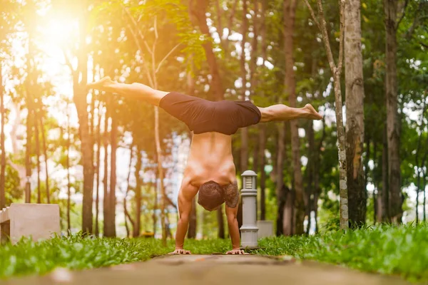 Young asian man are wiping sweat and doing yoga exercises in park. Yoga concept.