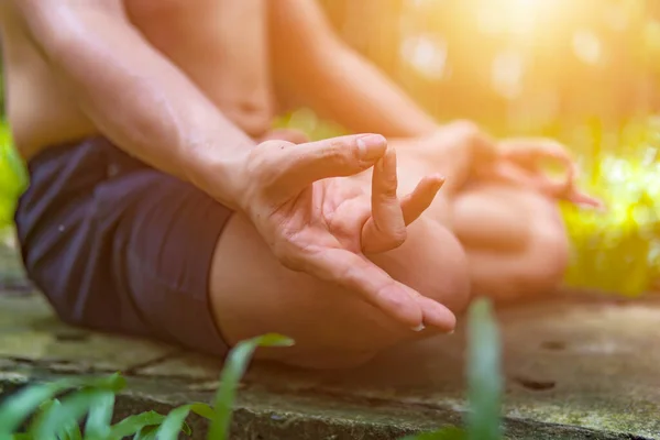 Close up hands. Asian man do yoga relax outdoor. Man exercising pose vital and meditation for fitness lifestyle club at the outdoors nature background. Healthy and Yoga Concept. Selective focus.