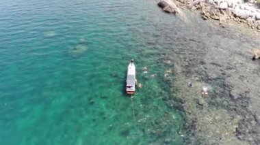 Binh Hung adasının turistlerle, balıkçı tekneleriyle, balıkçı köyleriyle ve yüzen botlarıyla Ninh Thuan eyaletinde deniz ürünleri yetiştiren sallarla dolu havadan görünüşü, Vietnam