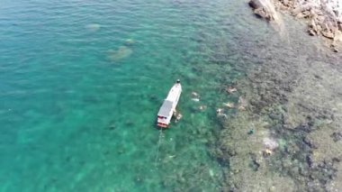 Binh Hung adasının turistlerle, balıkçı tekneleriyle, balıkçı köyleriyle ve yüzen botlarıyla Ninh Thuan eyaletinde deniz ürünleri yetiştiren sallarla dolu havadan görünüşü, Vietnam