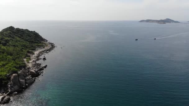 Vue aérienne de l'île de Binh Hung avec des touristes, des bateaux de pêche, des villages de pêcheurs et des radeaux flottants élevant des fruits de mer dans la province de Ninh Thuan, Vietnam 