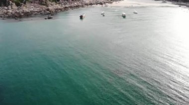 Binh Hung adasının turistlerle, balıkçı tekneleriyle, balıkçı köyleriyle ve yüzen botlarıyla Ninh Thuan eyaletinde deniz ürünleri yetiştiren sallarla dolu havadan görünüşü, Vietnam