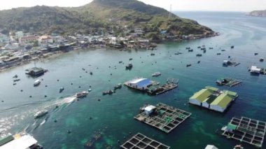 Binh Hung adasının turistlerle, balıkçı tekneleriyle, balıkçı köyleriyle ve yüzen botlarıyla Ninh Thuan eyaletinde deniz ürünleri yetiştiren sallarla dolu havadan görünüşü, Vietnam