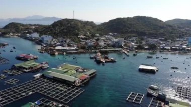 Binh Hung adasının turistlerle, balıkçı tekneleriyle, balıkçı köyleriyle ve yüzen botlarıyla Ninh Thuan eyaletinde deniz ürünleri yetiştiren sallarla dolu havadan görünüşü, Vietnam