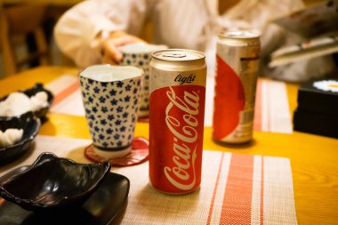 Ho Chi Minh şehri, Vietnam - 22 Haziran 2020: Masada serin Cocacola kutuları, Ho Chi Minh, Vietnam 'da bir Japon suşi restoranında masa.