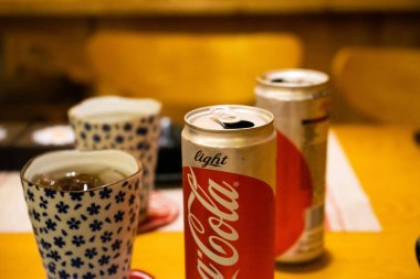 Ho Chi Minh şehri, Vietnam - 22 Haziran 2020: Masada serin Cocacola kutuları, Ho Chi Minh, Vietnam 'da bir Japon suşi restoranında masa.