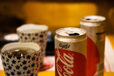 Ho Chi Minh şehri, Vietnam - 22 Haziran 2020: Masada serin Cocacola kutuları, Ho Chi Minh, Vietnam 'da bir Japon suşi restoranında masa.