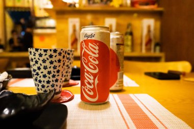 Ho Chi Minh şehri, Vietnam - 22 Haziran 2020: Masada serin Cocacola kutuları, Ho Chi Minh, Vietnam 'da bir Japon suşi restoranında masa.