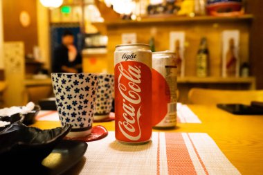 Ho Chi Minh şehri, Vietnam - 22 Haziran 2020: Masada serin Cocacola kutuları, Ho Chi Minh, Vietnam 'da bir Japon suşi restoranında masa.