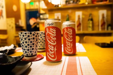 Ho Chi Minh şehri, Vietnam - 22 Haziran 2020: Masada serin Cocacola kutuları, Ho Chi Minh, Vietnam 'da bir Japon suşi restoranında masa.
