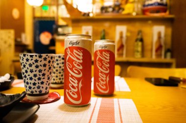 Ho Chi Minh şehri, Vietnam - 22 Haziran 2020: Masada serin Cocacola kutuları, Ho Chi Minh, Vietnam 'da bir Japon suşi restoranında masa.