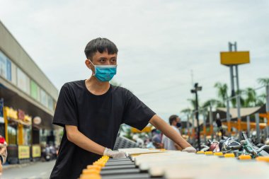 Covid-19 salgını. Tıbbi tek kullanımlık eldivenler ve süpermarket alışveriş arabalı maske takan adamların ellerini kapatın. İnsanlar karantina sırasında yiyecek almak için markete gidiyorlar. Sağlık ve Tıp Konsepti.