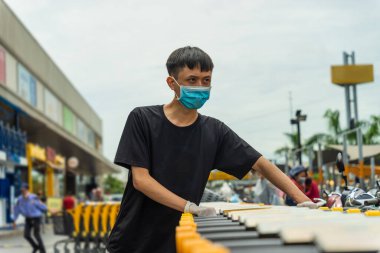 Covid-19 salgını. Tıbbi tek kullanımlık eldivenler ve süpermarket alışveriş arabalı maske takan adamların ellerini kapatın. İnsanlar karantina sırasında yiyecek almak için markete gidiyorlar. Sağlık ve Tıp Konsepti.