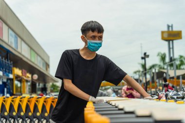 Covid-19 salgını. Tıbbi tek kullanımlık eldivenler ve süpermarket alışveriş arabalı maske takan adamların ellerini kapatın. İnsanlar karantina sırasında yiyecek almak için markete gidiyorlar. Sağlık ve Tıp Konsepti.