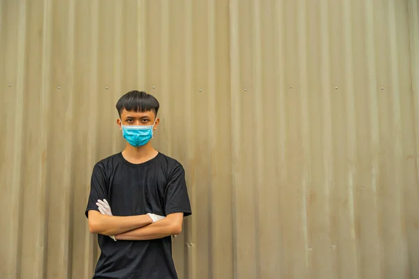 インフルエンザやウイルスを守るために顔の上に保護衛生マスクをしたアジア系の青年 明るい茶色の背景を持つ感染した男性の肖像画の不適切なインフルエンザ Covid19とコロナウイルス — ストック写真