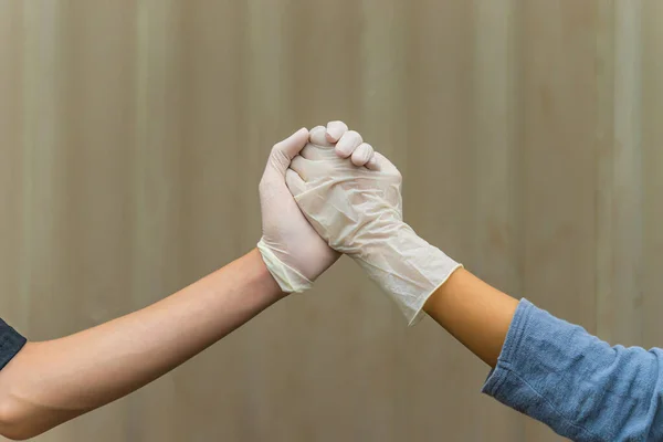 Handshake with white medical gloves, rubber glove for professional medical safety and hygiene protection from Coronavirus disease. Healthcare and medical concept.
