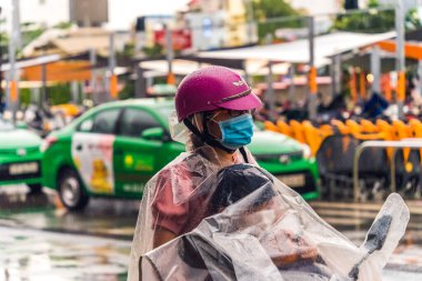 Ho Chi Minh şehri, Vietnam - 08 Ağustos 2020: Yerel halk Emart süpermarketinden alışveriş yapıyor, tıbbi maskeler takıyor, yağmurda motosiklet sürüyor ve Covid-19 salgınında sosyal mesafeyi koruyorlar.