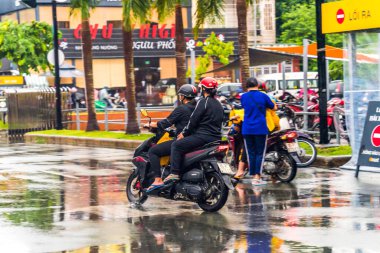 Ho Chi Minh şehri, Vietnam - 08 Ağustos 2020: Yerel halk Emart süpermarketinden alışveriş yapıyor, tıbbi maskeler takıyor, yağmurda motosiklet sürüyor ve Covid-19 salgınında sosyal mesafeyi koruyorlar.