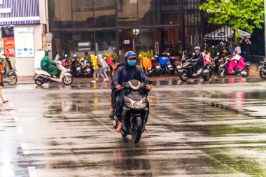 Ho Chi Minh şehri, Vietnam - 08 Ağustos 2020: Yerel halk Emart süpermarketinden alışveriş yapıyor, tıbbi maskeler takıyor, yağmurda motosiklet sürüyor ve Covid-19 salgınında sosyal mesafeyi koruyorlar.
