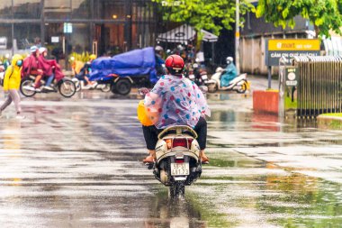 Ho Chi Minh şehri, Vietnam - 08 Ağustos 2020: Yerel halk Emart süpermarketinden alışveriş yapıyor, tıbbi maskeler takıyor, yağmurda motosiklet sürüyor ve Covid-19 salgınında sosyal mesafeyi koruyorlar.