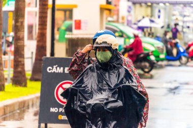 Ho Chi Minh şehri, Vietnam - 08 Ağustos 2020: Yerel halk Emart süpermarketinden alışveriş yapıyor, tıbbi maskeler takıyor, yağmurda motosiklet sürüyor ve Covid-19 salgınında sosyal mesafeyi koruyorlar.