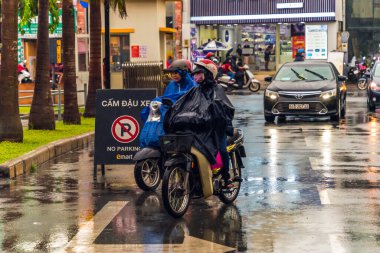 Ho Chi Minh şehri, Vietnam - 08 Ağustos 2020: Yerel halk Emart süpermarketinden alışveriş yapıyor, tıbbi maskeler takıyor, yağmurda motosiklet sürüyor ve Covid-19 salgınında sosyal mesafeyi koruyorlar.
