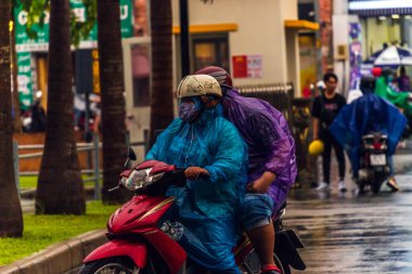 Ho Chi Minh şehri, Vietnam - 08 Ağustos 2020: Yerel halk Emart süpermarketinden alışveriş yapıyor, tıbbi maskeler takıyor, yağmurda motosiklet sürüyor ve Covid-19 salgınında sosyal mesafeyi koruyorlar.
