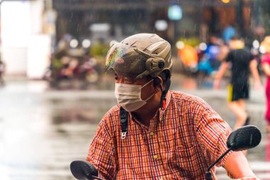 Ho Chi Minh şehri, Vietnam - 08 Ağustos 2020: Yerel halk Emart süpermarketinden alışveriş yapıyor, tıbbi maskeler takıyor, yağmurda motosiklet sürüyor ve Covid-19 salgınında sosyal mesafeyi koruyorlar.
