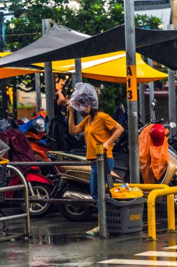 Ho Chi Minh şehri, Vietnam - 08 Ağustos 2020: Yerel halk Emart süpermarketinden alışveriş yapıyor, tıbbi maskeler takıyor, yağmurda motosiklet sürüyor ve Covid-19 salgınında sosyal mesafeyi koruyorlar.