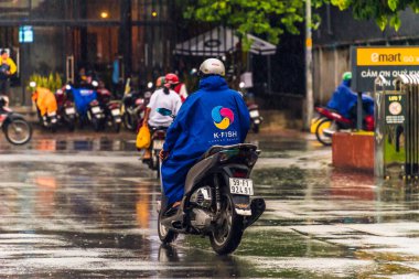 Ho Chi Minh şehri, Vietnam - 08 Ağustos 2020: Yerel halk Emart süpermarketinden alışveriş yapıyor, tıbbi maskeler takıyor, yağmurda motosiklet sürüyor ve Covid-19 salgınında sosyal mesafeyi koruyorlar.