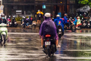 Ho Chi Minh şehri, Vietnam - 08 Ağustos 2020: Yerel halk Emart süpermarketinden alışveriş yapıyor, tıbbi maskeler takıyor, yağmurda motosiklet sürüyor ve Covid-19 salgınında sosyal mesafeyi koruyorlar.