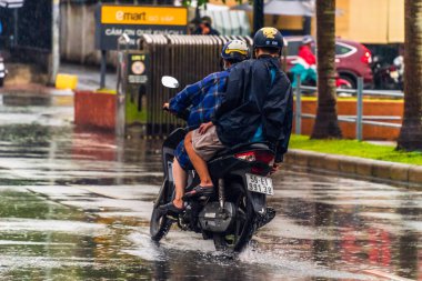 Ho Chi Minh şehri, Vietnam - 08 Ağustos 2020: Yerel halk Emart süpermarketinden alışveriş yapıyor, tıbbi maskeler takıyor, yağmurda motosiklet sürüyor ve Covid-19 salgınında sosyal mesafeyi koruyorlar.