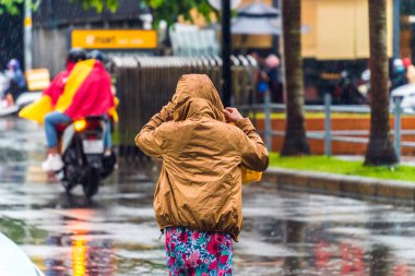 Ho Chi Minh şehri, Vietnam - 08 Ağustos 2020: Yerel halk Emart süpermarketinden alışveriş yapıyor, tıbbi maskeler takıyor, yağmurda motosiklet sürüyor ve Covid-19 salgınında sosyal mesafeyi koruyorlar.