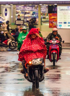Ho Chi Minh şehri, Vietnam - 08 Ağustos 2020: Yerel halk Emart süpermarketinden alışveriş yapıyor, tıbbi maskeler takıyor, yağmurda motosiklet sürüyor ve Covid-19 salgınında sosyal mesafeyi koruyorlar.
