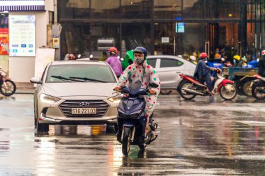 Ho Chi Minh şehri, Vietnam - 08 Ağustos 2020: Yerel halk Emart süpermarketinden alışveriş yapıyor, tıbbi maskeler takıyor, yağmurda motosiklet sürüyor ve Covid-19 salgınında sosyal mesafeyi koruyorlar.