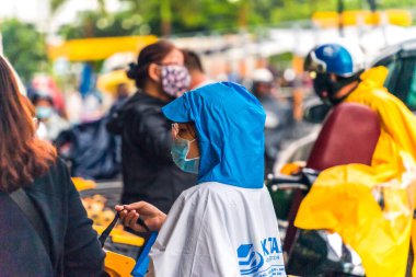 Ho Chi Minh şehri, Vietnam - 08 Ağustos 2020: Yerel halk Emart süpermarketinden alışveriş yapıyor, tıbbi maskeler takıyor, yağmurda motosiklet sürüyor ve Covid-19 salgınında sosyal mesafeyi koruyorlar.