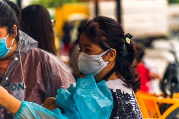 Ho Chi Minh şehri, Vietnam - 08 Ağustos 2020: Yerel halk Emart süpermarketinden alışveriş yapıyor, tıbbi maskeler takıyor, yağmurda motosiklet sürüyor ve Covid-19 salgınında sosyal mesafeyi koruyorlar.