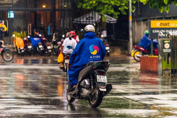 Ho Chi Minh şehri, Vietnam - 08 Ağustos 2020: Yerel halk Emart süpermarketinden alışveriş yapıyor, tıbbi maskeler takıyor, yağmurda motosiklet sürüyor ve Covid-19 salgınında sosyal mesafeyi koruyorlar.